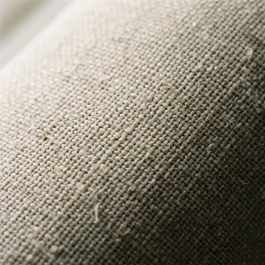 Extreme close-up macro of woven natural undyed linen upholstery showing individual threads and subtle texture